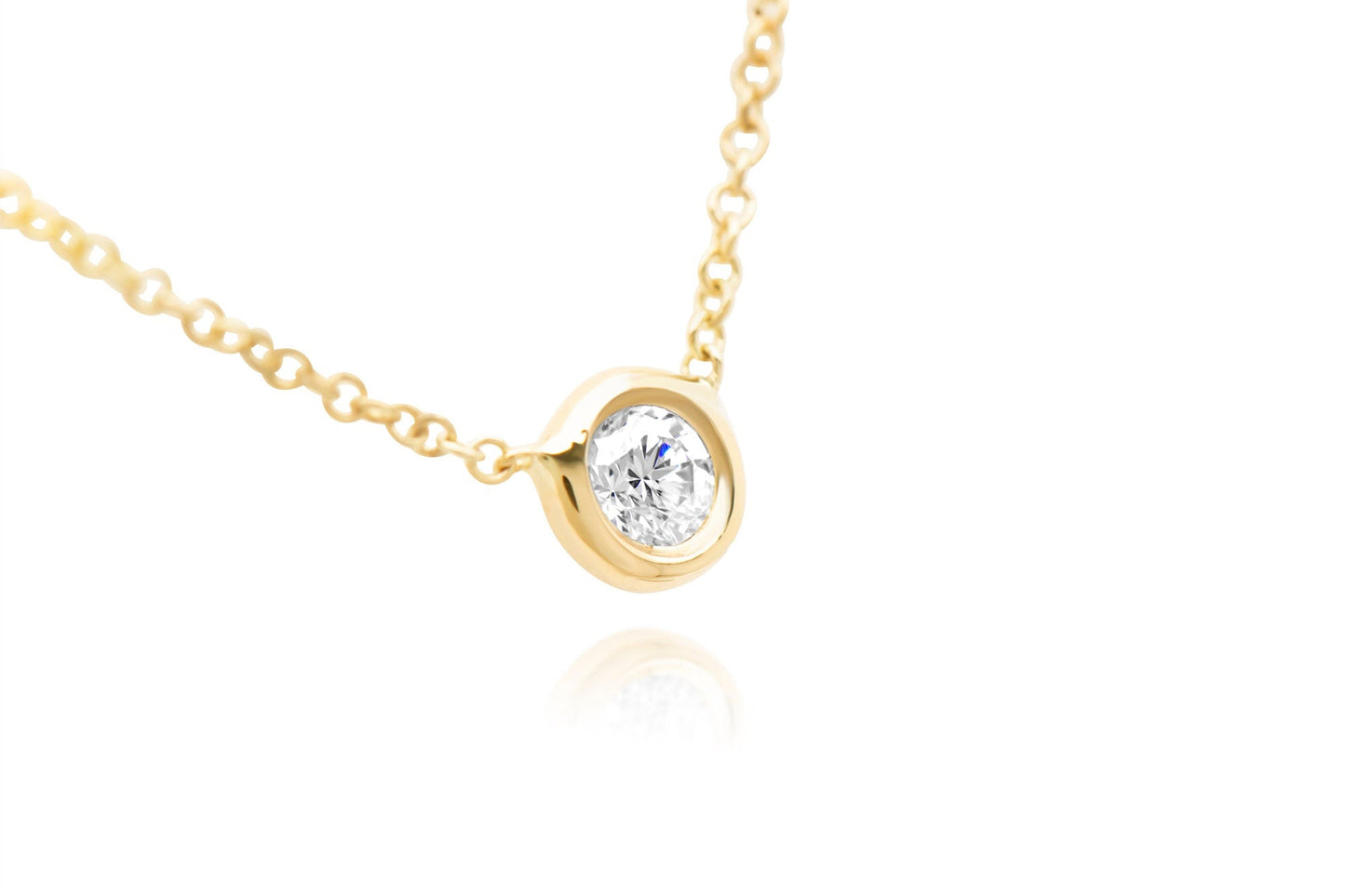 A closeup of 14k Rose Gold Bezel Set Diamond Pendant of .05ct. 