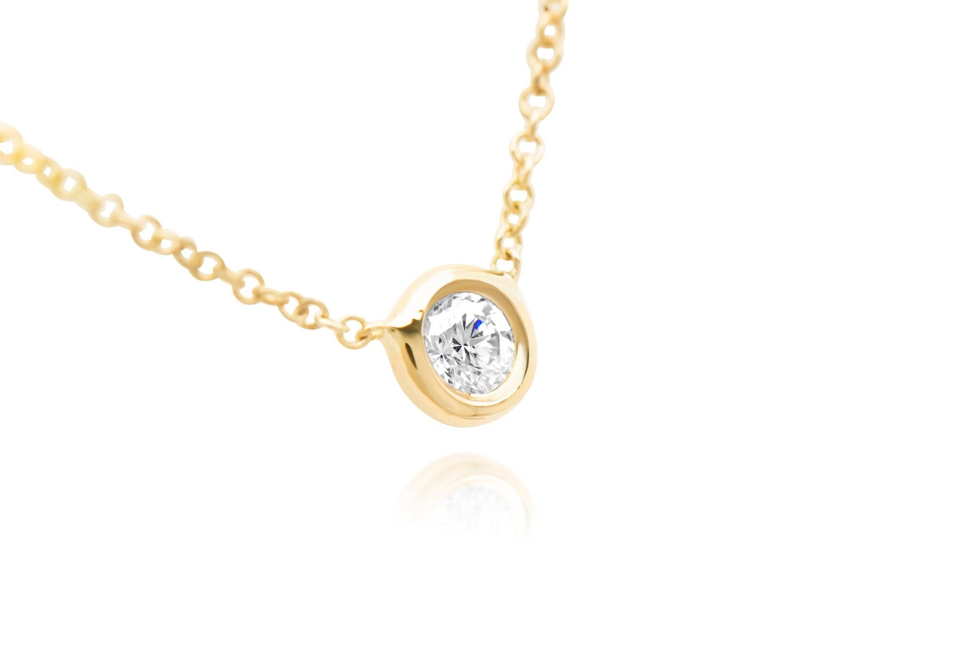 A closeup of 14k Rose Gold Bezel Set Diamond Pendant of .05ct. 